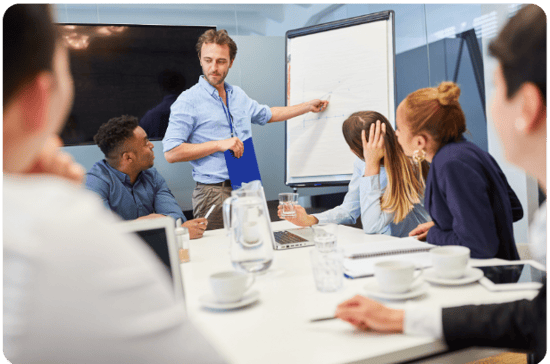 man sleeves rolled up at whiteboard leading team